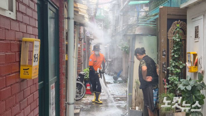서울 낮 최고기온이 36.0도를 기록한 9일 오후 2시 30분쯤 서울 종로구 돈의동 쪽방촌 골목에서 소방당국이 지열을 가라앉히기 위한 살수 작업을 벌이고 있다. 송선교 기자