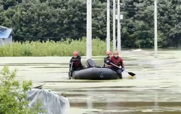17일 낮 12시 23분쯤 충남 공주시 사곡면의 둑이 무너졌다. 축사로 물이 들어와 고립되자 소방당국이 보트를 이용해 구조하고 있는 모습. 충남소방본부 제공 영상 캡처