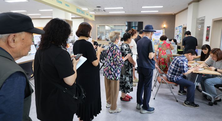 민생회복 소비쿠폰 1차 신청 첫날일 21일 인천 미추홀구 숭의1·3동 행정복지센터에서 시민들이 소비쿠폰 신청 순서를 기다리고 있다. 연합뉴스