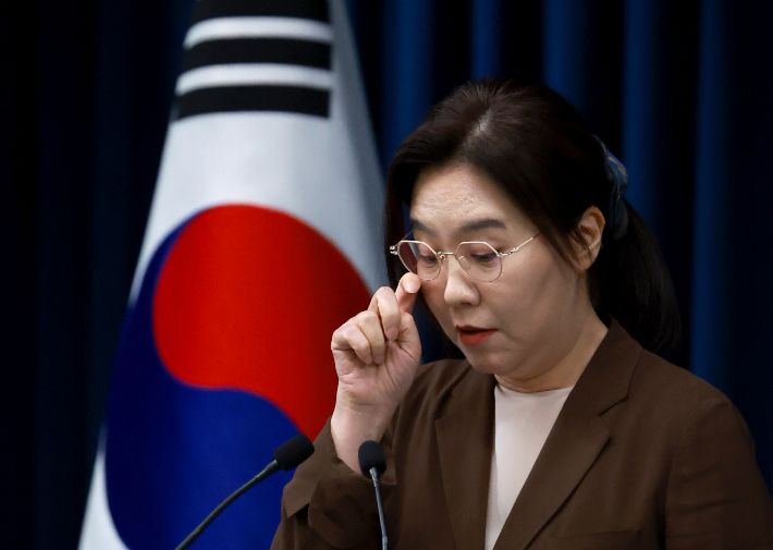 강유정 대통령실 대변인이 5일 서울 용산 대통령실 청사에서 현안 브리핑을 마친 뒤 취재진 질문에 답하며 자료를 살피고 있다. 연합뉴스