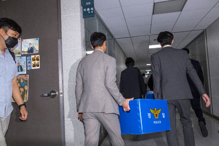 서울경찰청 금융범죄수사대 전담수사팀 관계자들이 지난 11일 주식 차명거래 혐의를 받는 이춘석 의원의 국회 사무실 압수수색을 마친 뒤 압수품을 들고 의원실을 나서는 모습. 연합뉴스