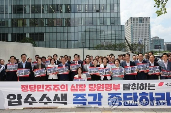 (서울=연합뉴스) 이진욱 기자 = 국민의힘 송언석 비대위원장 겸 원내대표 등 의원들이 18일 김건희 여사 관련 의혹을 수사하는 민중기 특별검사팀 사무실이 마련된 서울 종로구 KT 광화문빌딩 웨스트 앞에서 현장 비상의원총회를 열고 야당탄압 정치보복 압수수색 규탄 손팻말을 들고 있다. 2025.8.18     cityboy@yna.co.kr (끝) 연합뉴스