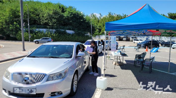 5일 오후 강릉시 스피드스케이팅경기장 주차장에 마련한 '드라이브 스루'를 통해 생수를 받으러 온 차량들이 접수하고 있는 모습. 전영래 기자