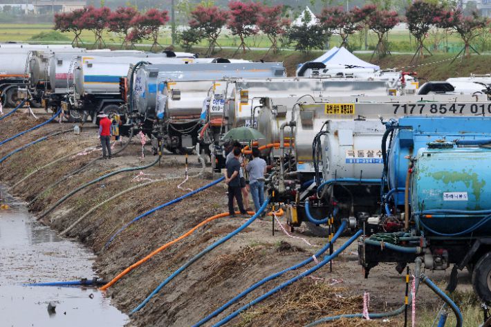 최악의 가뭄이 이어지는 7일 강원 강릉의 한 하천에서 살수차들이 비가 내리는 가운데 운반급수를 위해 줄지어 취수하고 있다. 연합뉴스