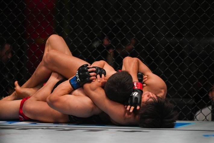 타이라(사진 오른쪽)의 리어네이키드 초크 기술에 걸려든 박현성. UFC 제공