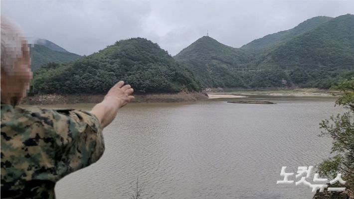 오봉저수지 안에 섬으로 불리는 말구리재를 가리키고 잇는 한 시민. 전영래 기자