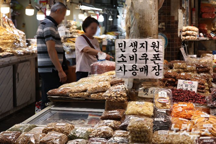 민생회복 소비쿠폰 2차 지급계획이 발표된 12일 서울 동대문구 청량리종합시장 내 점포에 민생회복 소비쿠폰 사용 가능 안내문이 붙어 있다. 류영주 기자