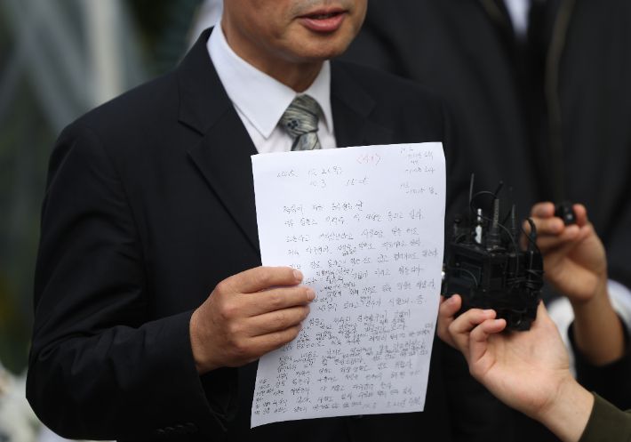 지난 10일 자택에서 숨진 채 발견된 경기 양평군청 소속 50대 사무관 A씨의 변호사인 박경호 국민의힘 대전 대덕 당협위원장이 14일 광화문 KT 빌딩 앞에서 고인의 생전 메모를 들고 기자회견을 하고 있다. 연합뉴스