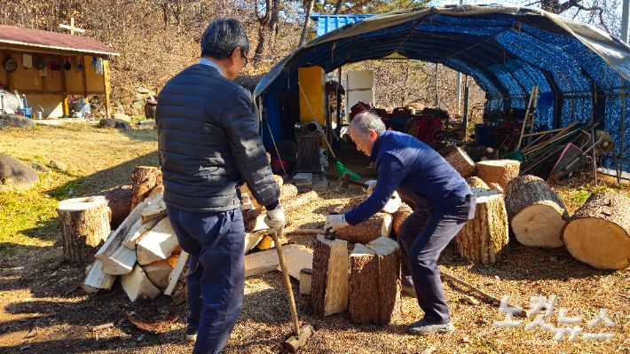 강원도 홍천군 화촌면 도심리교회 홍동완 목사(오른쪽)가 마을 주민의 집을 찾아 화목보일러용 장작을 준비하고 있다. 송주열 기자