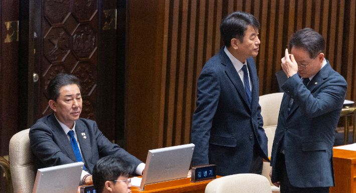 더불어민주당 김병기 전 원내대표(왼쪽)와 문진석 원내운영수석부대표(가운데), 허영 원내정책수석부대표가 30일 국회에서 열린 2025년도 마지막 본회의인 12월 임시국회 3차 본회의에서 심각한 표정으로 대화하고 있다. 연합뉴스