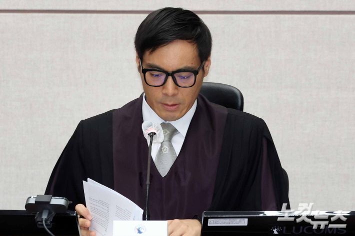윤석열 전 대통령의 특수공무집행방해, 직권남용 권리행사방해 등 혐의 사건 첫 공판이 열린 26일 서울 서초구 서울중앙지법에서 백대현 부장판사가 자료를 살펴보고 있다. 사진공동취재단
