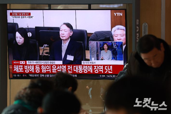 16일 오후 서울역 대합실에서 시민들이 고위공직자범죄수사처(공수처) 체포 방해 혐의 등으로 기소된 윤석열 전 대통령에 대한 1심 선고 공판 생중계를 지켜보고 있다. 류영주 기자