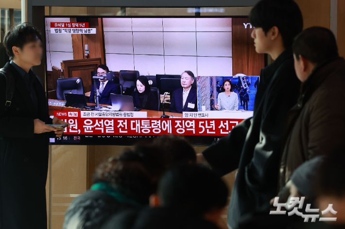 16일 오후 서울역 대합실에서 시민들이 고위공직자범죄수사처(공수처) 체포 방해 혐의 등으로 기소된 윤석열 전 대통령에 대한 1심 선고 공판 생중계를 지켜보고 있다. 류영주 기자