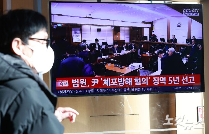 16일 오후 서울역 대합실에서 시민들이 고위공직자범죄수사처(공수처) 체포 방해 혐의 등으로 기소된 윤석열 전 대통령에 대한 1심 선고 공판 생중계를 지켜보고 있다. 류영주 기자