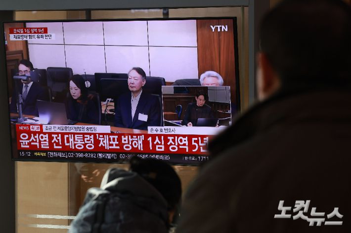 16일 오후 서울역 대합실에서 시민들이 고위공직자범죄수사처(공수처) 체포 방해 혐의 등으로 기소된 윤석열 전 대통령에 대한 1심 선고 공판 생중계를 지켜보고 있다. 류영주 기자