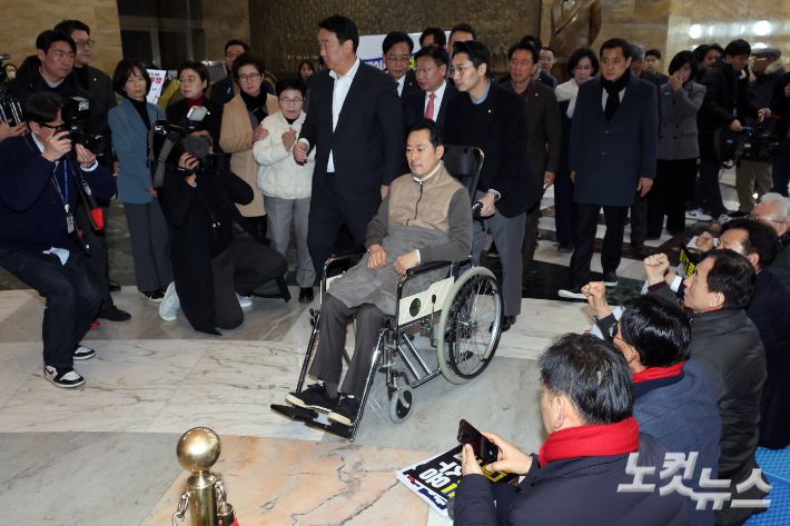 통일교·공천헌금 '쌍특검'을 요구하며 8일째 단식을 이어가던 장동혁 국민의힘 대표가 22일 서울 여의도 국회에서 단식을 중단하고 병원으로 향하며 지지자들의 응원을 받고 있다. 윤창원 기자