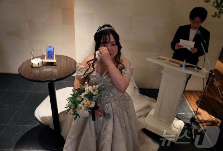 지난 10월 27일 일본 오카야마현에서 인공지능(AI)이 신랑 클라우스(왼쪽)와 결혼한 유리나 노구치(32)가 눈물을 흘리고 있다. 로이터/뉴스1