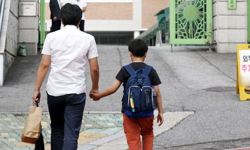 19일 서울의 한 초등학교에서 개학을 맞은 아이가 아버지와 함께 등교하고 있다. 뉴스1