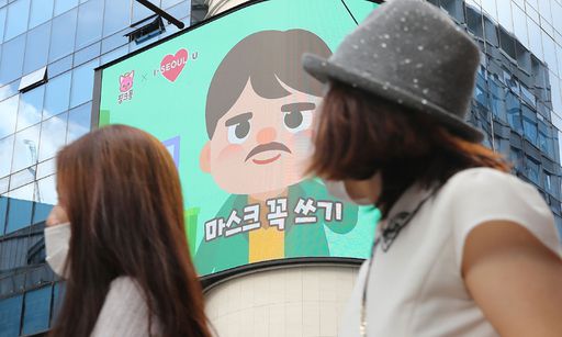 23일 서울 중구 명동거리에서 시민들이 전광판에 나오는 마스크 캠페인 화면을 보고 있다. 뉴스1