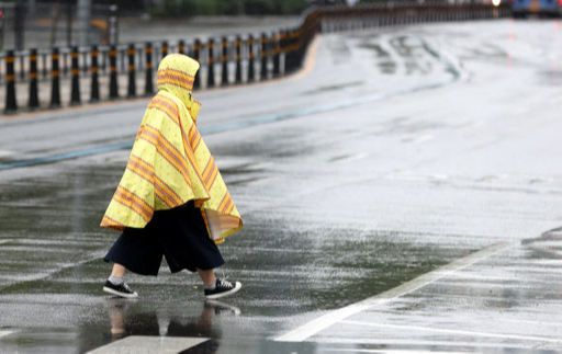 27일 오전 서울 광화문 거리에서 비옷을 입은 시민이 발길을 재촉하고 있다. 연합뉴스