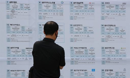 한 시민이 일자리 박람회 참여업체 리스트를 확인하고 있다. 연합뉴스