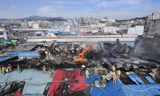 21일 새벽 화재가 발생한 서울 청량리 청과물 시장에서 소방관들이 무너진 시장 건물 지붕 위에서 잔불을 진화하고 있다. 이제원 기자