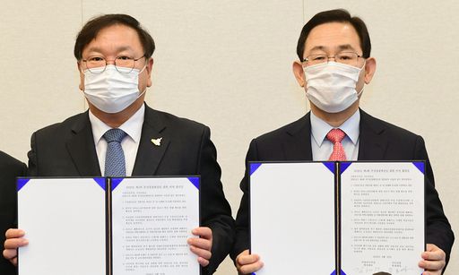 더불어민주당 김태년 원내대표(왼쪽)와 국민의힘 주호영 원내대표가 22일 국회에서 2020년도 제4차 추가경정예산안 합의사항 발표에서 합의문에 서명한 뒤 기념촬영을 하고 있다. 연합뉴스