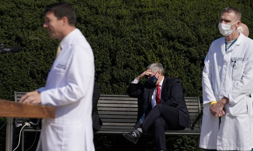 마크 메도스 미국 백악관 비서실장이 4일(현지시간) 코로나19로 도널드 트럼프 대통령이 입원해 있는 메릴랜드주 월터리드 군 병원에서 대통령 주치의 숀 콘리 박사의 브리핑이 진행되는 동안 인근 벤치에 기대어 앉아 손으로 이마를 감싸고 있다. 그가 “대통령의 상태가 아주 좋다”고 한 의료진의 설명과 상반된 내용을 언론에 밝혀 트럼프 대통령이 격노한 것으로 알려졌다. 베데스다=AP연합뉴스