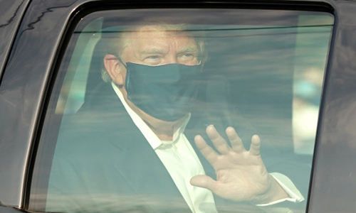 널드 트럼프 미국 대통령이 4일(현지시간) 신종 코로나바이러스 감염증(코로나19)으로 입원 중인 메릴랜드주 베세즈다의 월터 리드 군 병원 밖으로 차를 타고 나와 지지자들 앞을 지나면서 손을 흔들고 있다. AFP연합뉴스