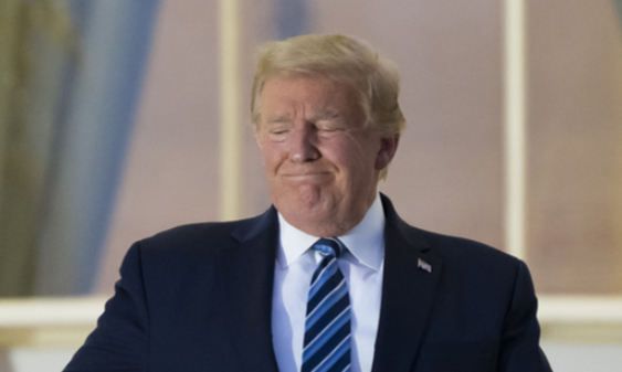 도널드 트럼프 미국 대통령이 5일(현지시간) 신종 코로나바이러스 감염증(코로나19) 치료를 받던 메릴랜드주 베데스다의 월터 리드 병원을 퇴원해 백악관으로 돌아온 뒤 블루룸의 트루먼 발코니에 나와 쓰고 있던 마스크를 벗어 양복 상의 주머니에 넣고 있다. 워싱턴 AP=연합뉴스