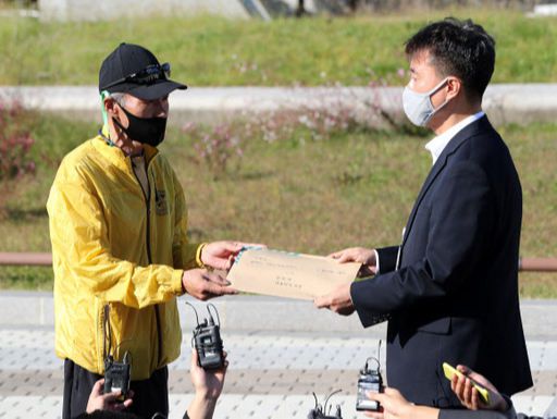 북한 피격 사망 공무원 A씨의 형 이래진씨가 지난 8일 서울 청와대 분수대 앞에서 시민사회수석실 행정관에게 A씨의 아들이 작성한 원본 편지를 전달하고 있다. 뉴스1