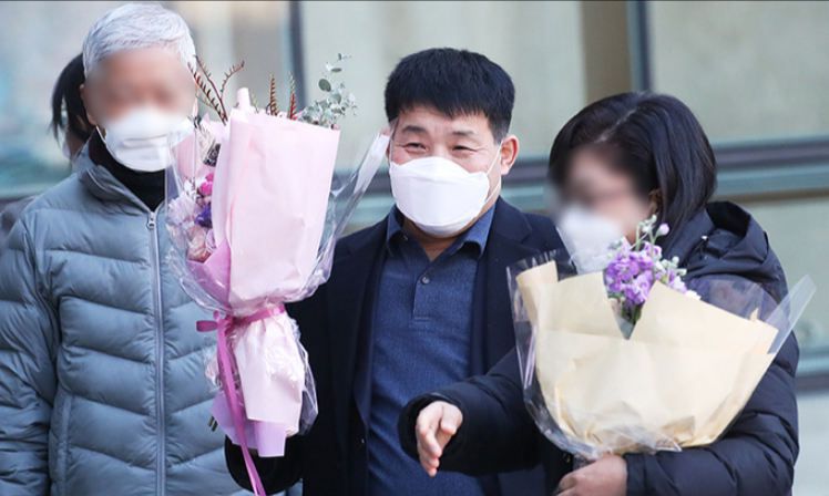 17일 오후 경기도 수원시 영통구 수원지방법원에서 열린 이춘재 연쇄살인 8차 사건 재심 선고공판에서 재심 청구인 윤성여 씨가 무죄를 선고받고 법원 청사를 나와 꽃다발을 받고 환하게 웃고 있다. 연합뉴스