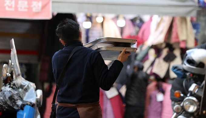 지난 28일 서울 중구 남대문 시장에서 한 음식점 종업원이 배달하고 있다. 연합뉴스