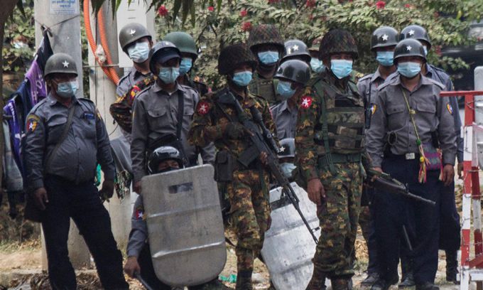 미얀마 군경이 20일(현지시간) 미얀마 만달레이에서 무장한 채 시위현장을 지켜보고 있다. 만달레이=AFP연합뉴스