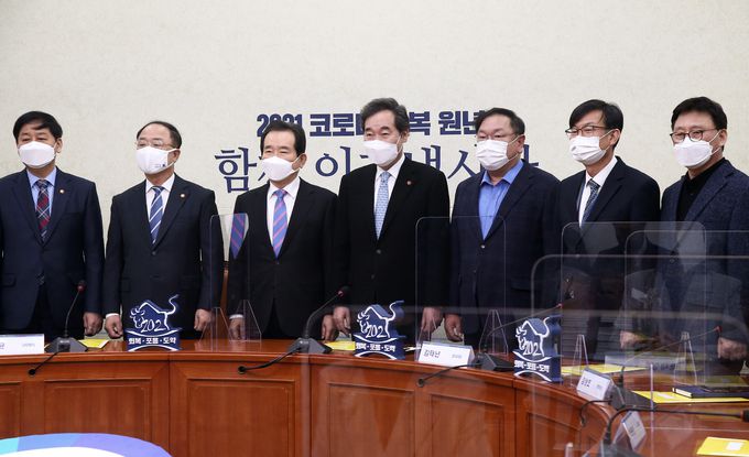 더불어민주당 이낙연 대표, 정세균 총리, 홍남기 경제부총리 등이 28일 국회에서 열린 제2차고위당정협의회에서 추경 및 재난지원금 논의에 앞서 기념촬영하고 있다. 왼쪽부터 구윤철 국무조정실장, 홍남기 경제부총리, 정세균 총리, 이낙연 대표, 김태년 원내대표, 김상조 청와대 정책실장, 박광온 사무총장. 연합뉴스