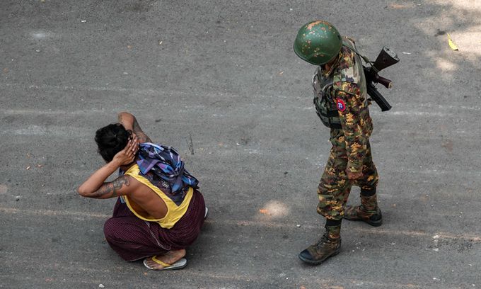 미얀마 제2의 도시 만달레이에서 3일(현지시간) 연행된 군부 쿠데타 규탄 시위 참가자 곁에 총을 멘 군인이 서 있다. 만달레이=AP연합뉴스