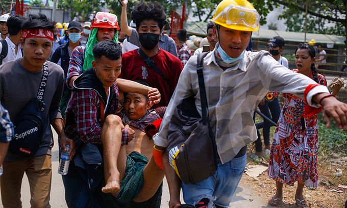 미얀마 최대 도시 양곤에서 14일 쿠데타 반대 시위가 벌어지는 도중 총격을 당한 시민이 동료 시위대원들에 의해 안전한 장소로 옮겨지고 있다. 양곤=AFP연합뉴스