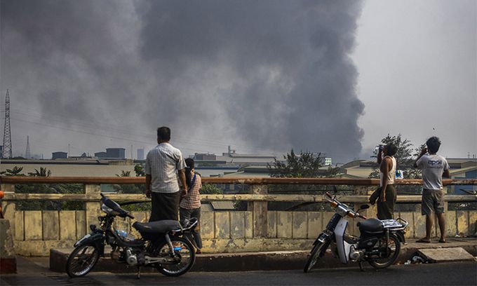 지난 14일(현지시간) 미얀마 최대 도시 양곤 외곽에 있는 흘라잉타야 산업단지에서 검은 연기가 솟아 오르고 있다. 미얀마 주재 중국대사관에 따르면 이날 흘라잉타야에 있는 중국계 공장 다수가 방화 및 약탈 피해를 본 것으로 알려졌다. 양곤=AP연합뉴스