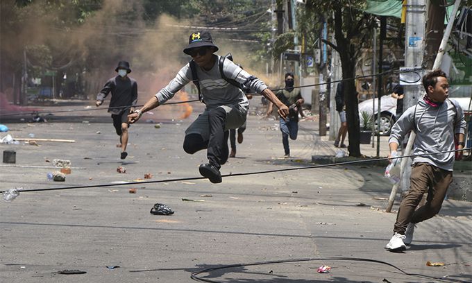 미얀마에서 유혈사태가 악화하는 가운데 지난 3월 31일(현지시간) 최대 도시 양곤에서 군부 쿠데타 규탄 시위대가 강경 진압에 나선 군인들을 피해 급히 달아나고 있다. 양곤=AP연합뉴스