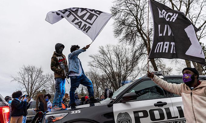 미국 미네소타주 미니애폴리스의 브루클린 센터에서 11일(현지시간) 경찰 총격에 20대 흑인 청년이 사망한 데 항의하는 시위대가 경찰차에 올라타 BLM(흑인 목숨도 소중하다) 깃발을 흔들고 있다. 미니애폴리스=AFP연합뉴스