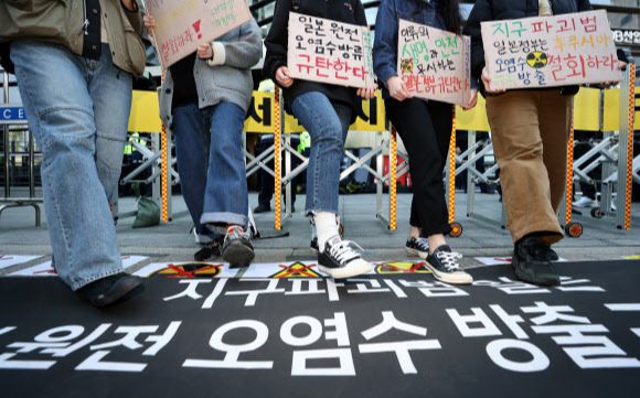 14일 오전 서울 종로구 일본대사관 앞에서 대학생기후행동 관계자 등이 일본 정부의 후쿠시마 원전 폐수 방류 결정을 규탄하며 퍼포먼스를 하고 있다. 연합뉴스