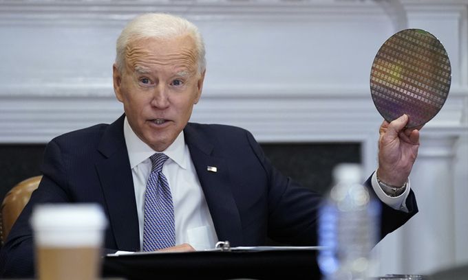 조 바이든 미국 대통령이 12일(현지시간) 백악관 루즈벨트룸에서 반도체 업계 대표들과 화상 회의를 진행하는 도중 실리콘 웨이퍼를 꺼내들고 있다. 워싱턴=AP연합뉴스