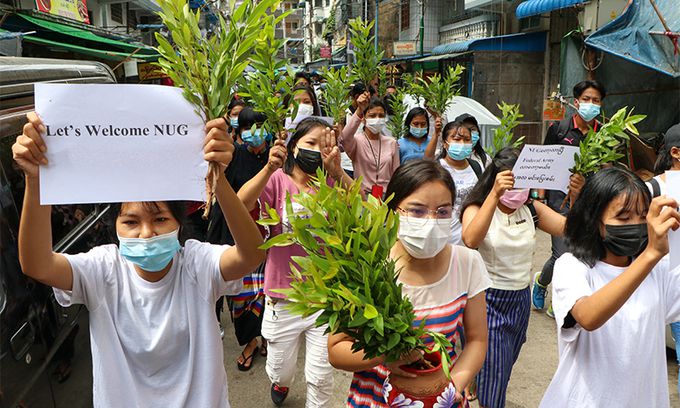 미얀마 전통 설인 17일(현지시간) 군부에 반대하는 시민들이 ‘국민통합정부(NUD) 환영’이라고 적힌 종이를 들고 양곤 거리를 행진하고 있다. 양곤=AP연합뉴스