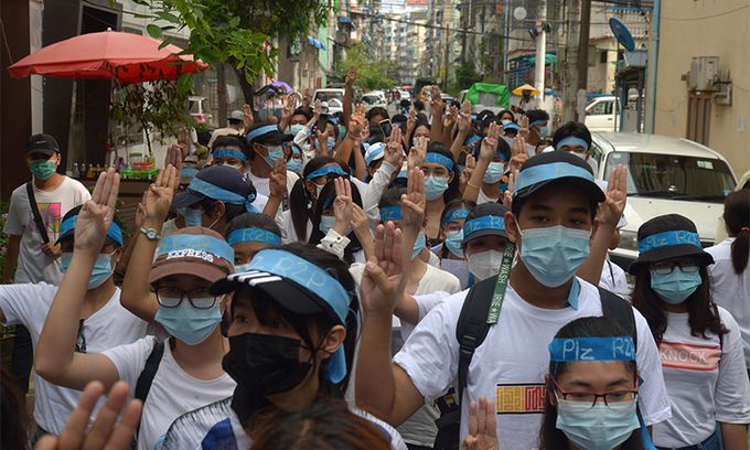 미얀마 최대 도시 양곤에서 지난 12일(현지시간) 군부 쿠데타 규탄 시위대가 'R2P'라고 쓰인 머리띠를 두르고 독재에 대한 저항을 상징하는 '세 손가락 경례'를 하고 있다. 양곤=AP연합뉴스