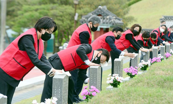 국민의힘 초선의원들이 10일 광주 북구 국립 5·18민주묘지에서 참배를 마친 뒤 묘비를 닦고 있다. 광주=뉴스1