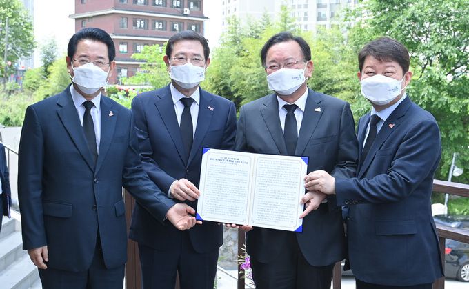 권영진 대구시장(오른쪽 첫번째)이 18일 김부겸 국무총리에게 달빛내륙철도의 제4차 국가철도망 구축계획 반영을 촉구하는 건의문을 전달하고 있다. 대구시 제공