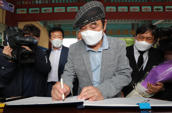 21일 오후 광주 북구 국립 5·18 민주묘지에서 1980년 5월 3공수여단 11지역대대장으로 광주에 투입됐던 신순용 전 소령이 참배하며 방명록을 쓰고 있다. 연합뉴스