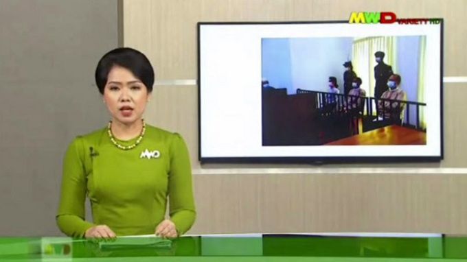 미얀마 군 방송 MWD 앵커가 24일(현지시간) 열린 아웅산 수치 국가고문의 첫 공판 소식을 전하는 모습. 네피도=AP연합뉴스