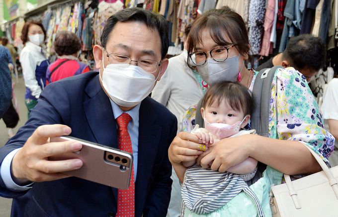 셀카 주호영 의원(왼쪽)이 27일 대구 중구 서문시장에서 아기를 안은 시민과 셀카를 찍고 있다. 대구=뉴시스