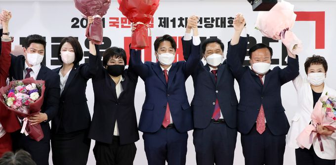 이준석 신임 대표(가운데)가 11일 국민의힘 전당대회에서 새 지도부로 선출된 김용태(왼쪽부터)·배현진·조수진 최고위원, 김기현 원내대표, 김재원·정미경 최고위원과 손을 맞잡고 당원들에게 인사하고 있다. 하상윤 기자